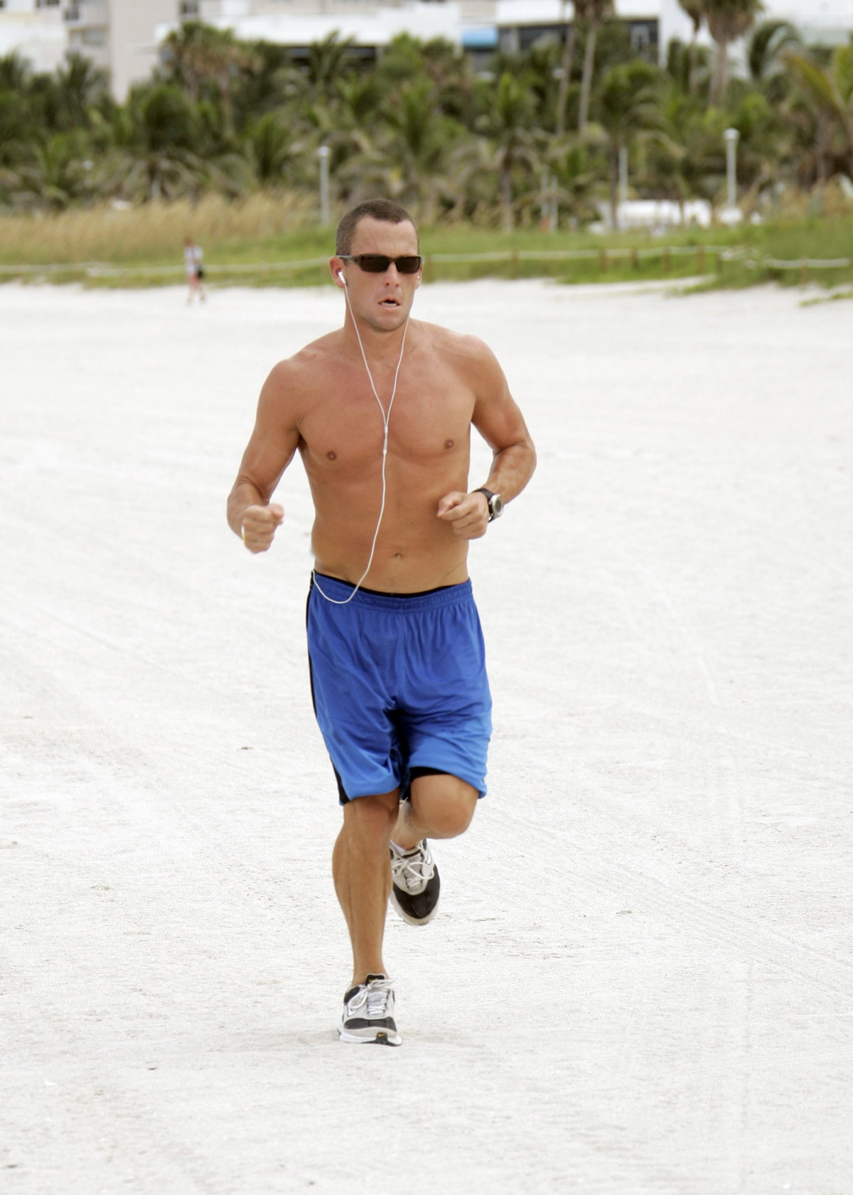 Lance Armstrong oberkörperfrei beim Joggen am Strand
