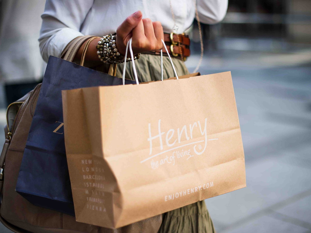 Frau mit zwei Tüten in der Hand beim Shoppen auf der Straße