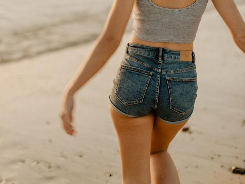 Mädchen mit Jeansshorts am Strand