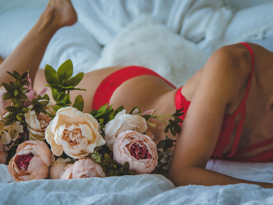 frau im bett in unterwäsche mit blumen