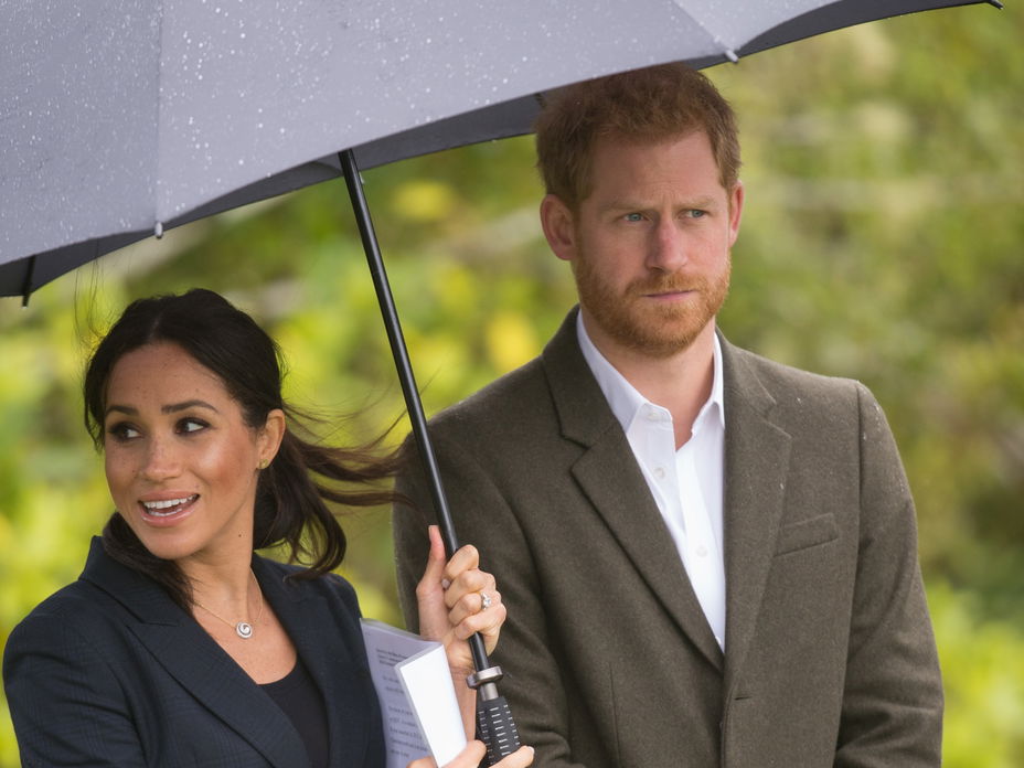 Meghan Markle hält den Regenschirm für Prinz Harry