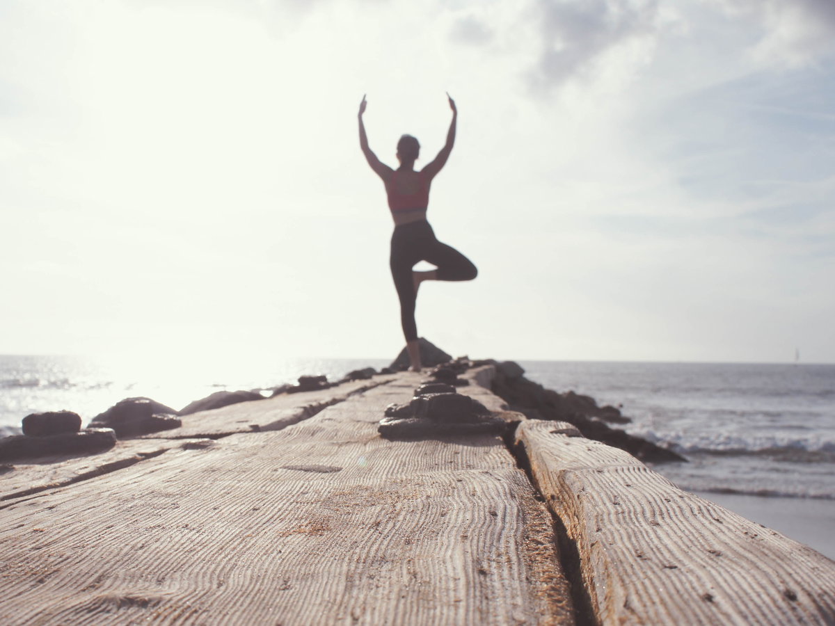 Frau macht Yoga auf Steg