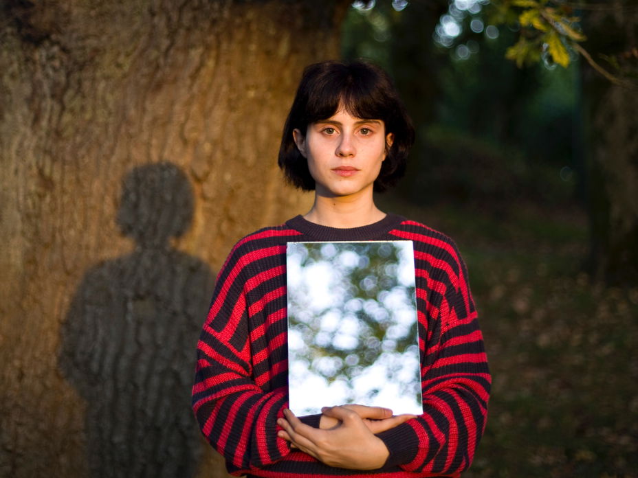 Frau hält Spiegel in der Hand