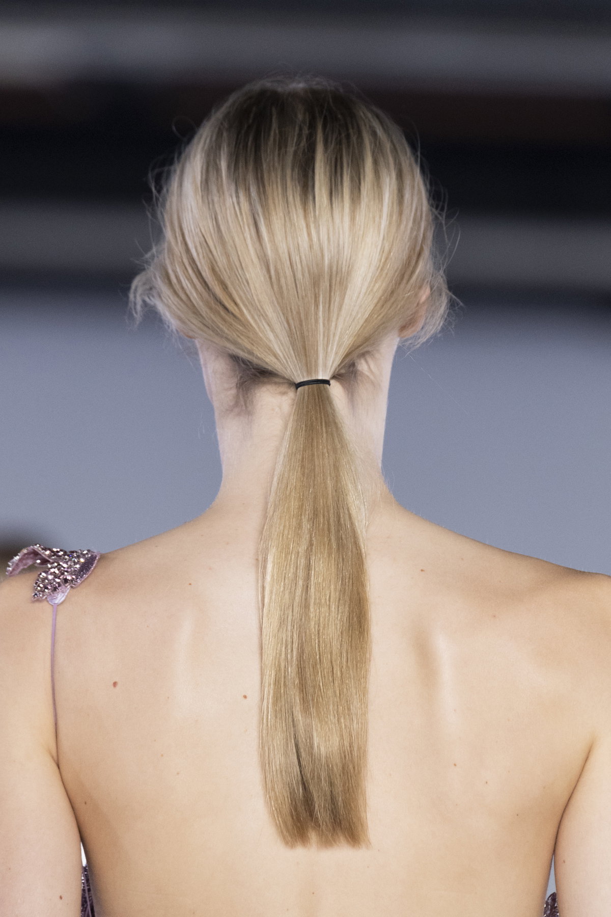 Blonde Haare zum tiefen Pferdeschwanz gebunden