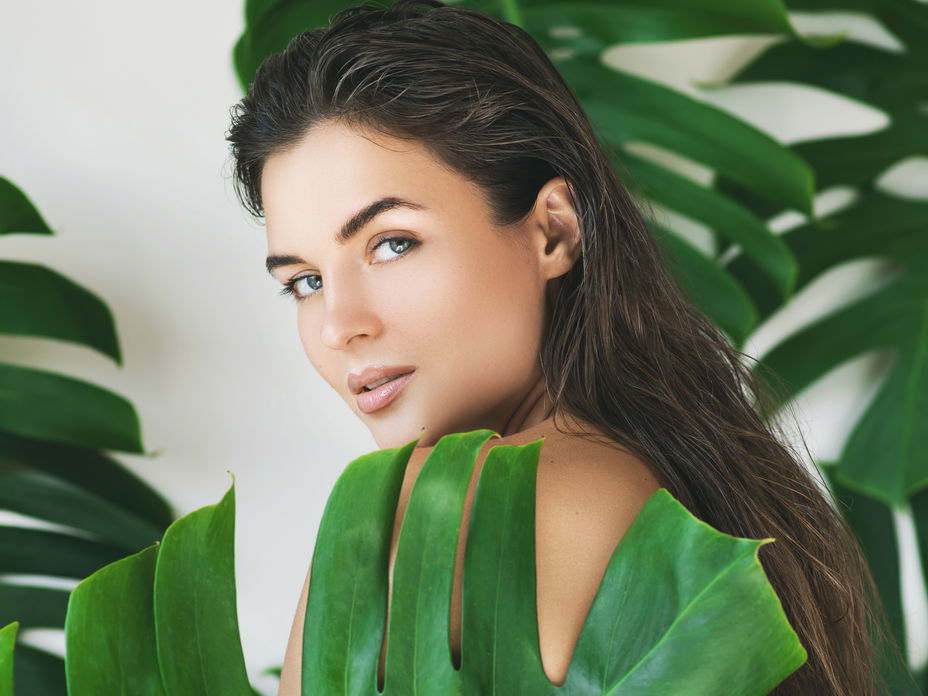 Brau mit Monstera-Blättern und schöner Haut