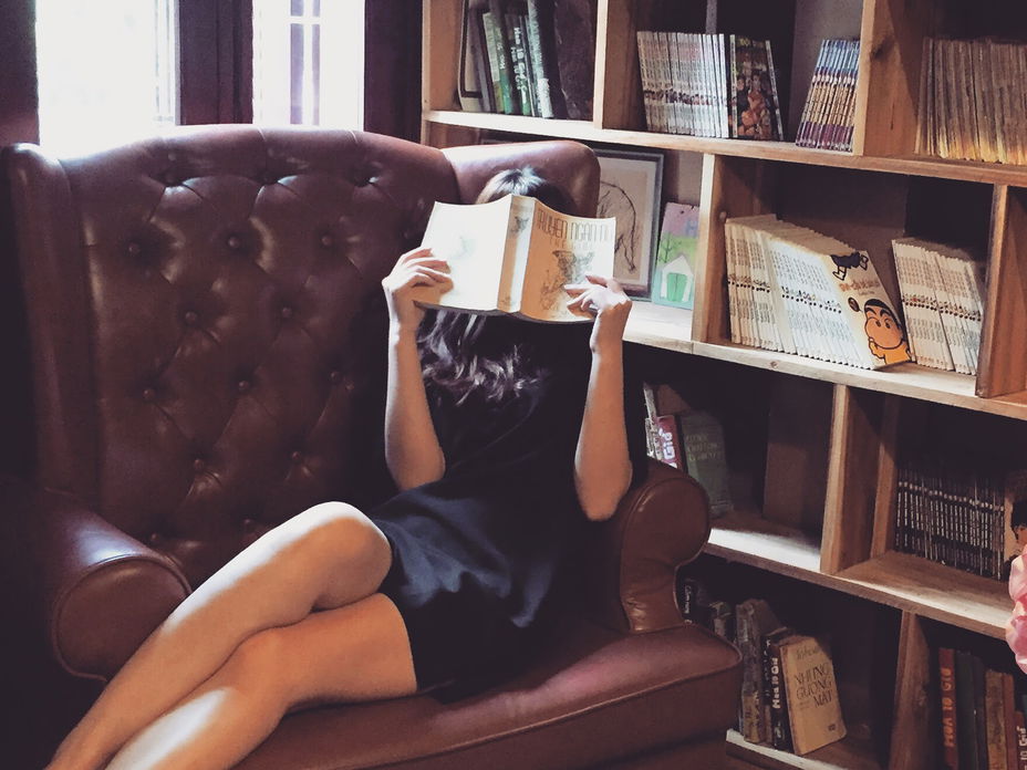 Mädchen mit Buch im Sessel