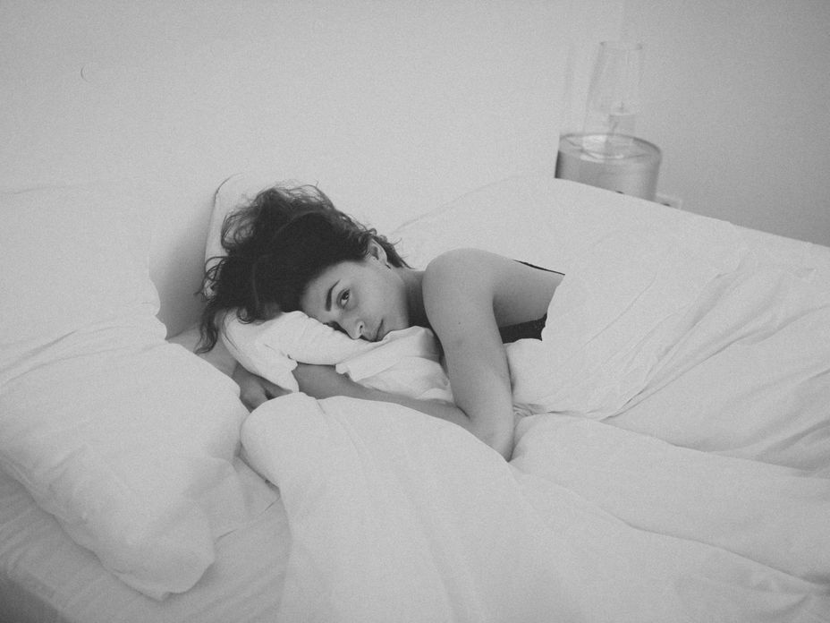 frau nackt im bett traurig