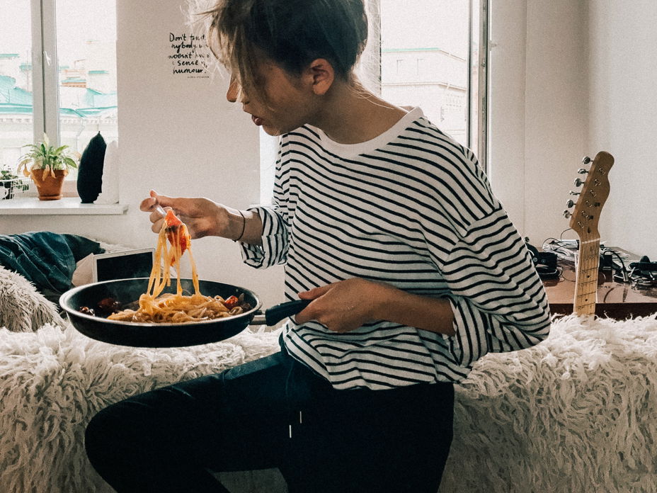 Frau mit Spaghetti in einer Pfanne