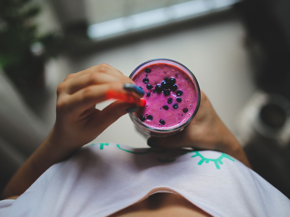 Frau hält Smoothie in der Hand