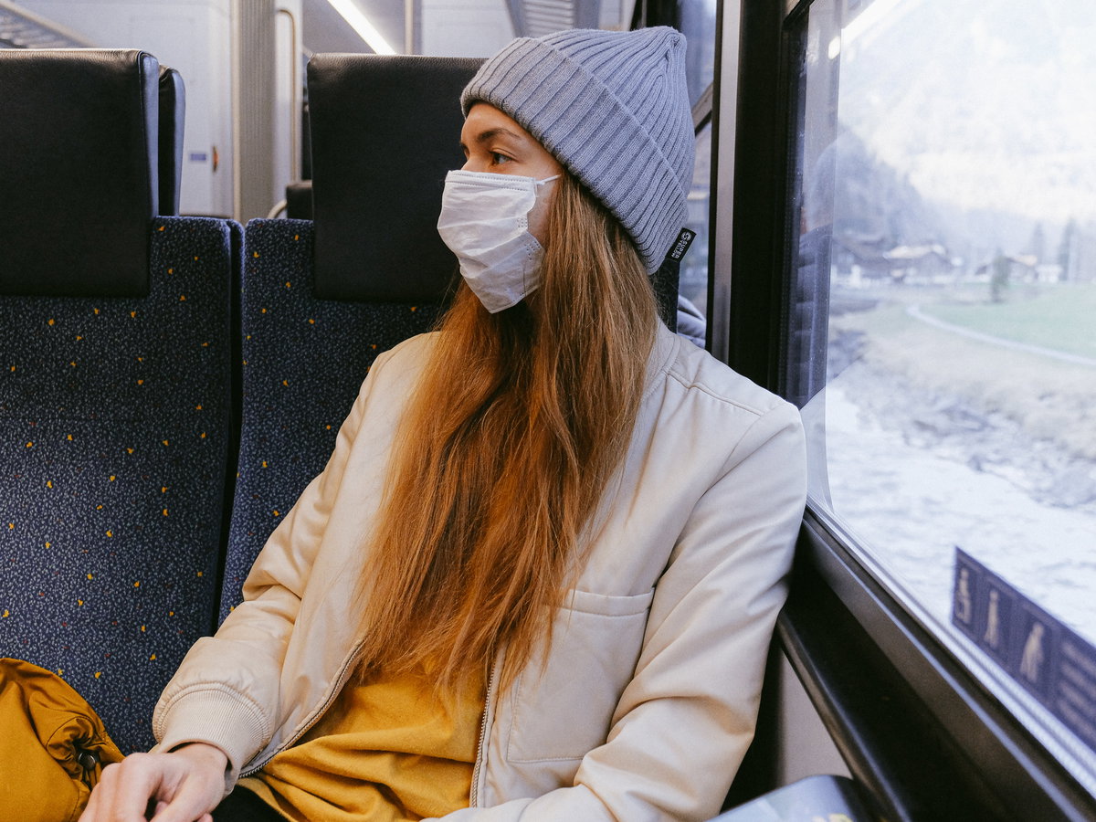 Frau trägt in der Bahn eine Atemschutzmaske