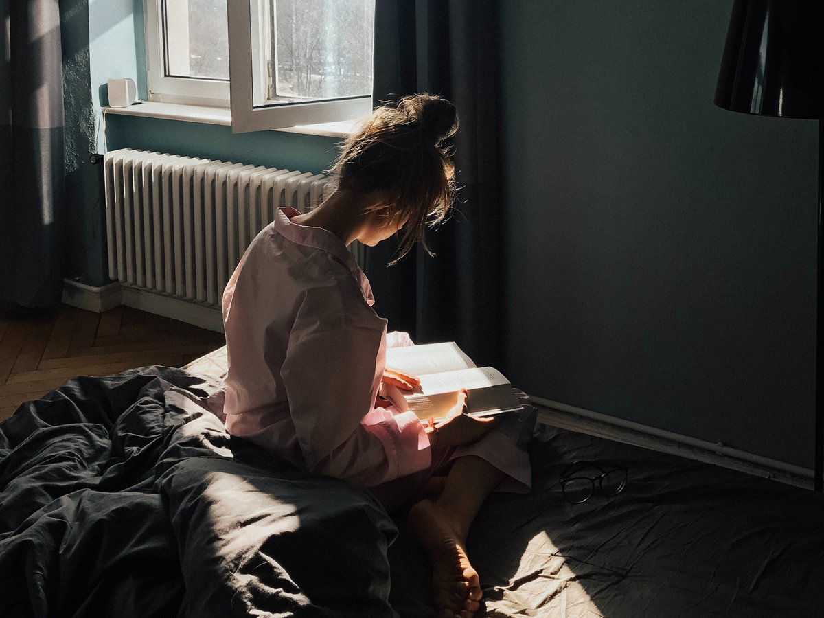 Mädchen auf Bett mit Buch