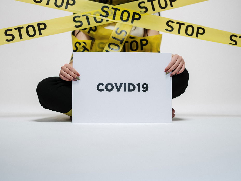 Mensch mit Corona Schild