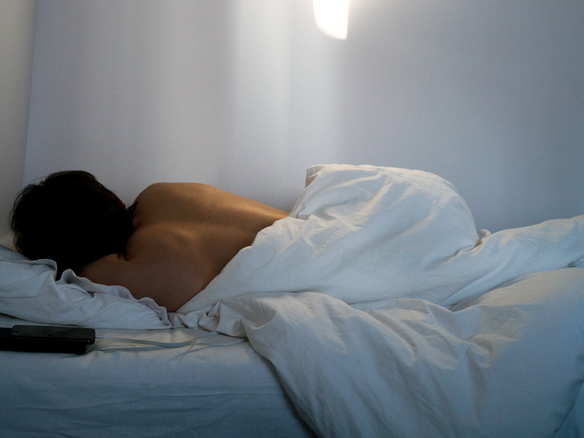 Rücken einer Frau die im Bett liegt