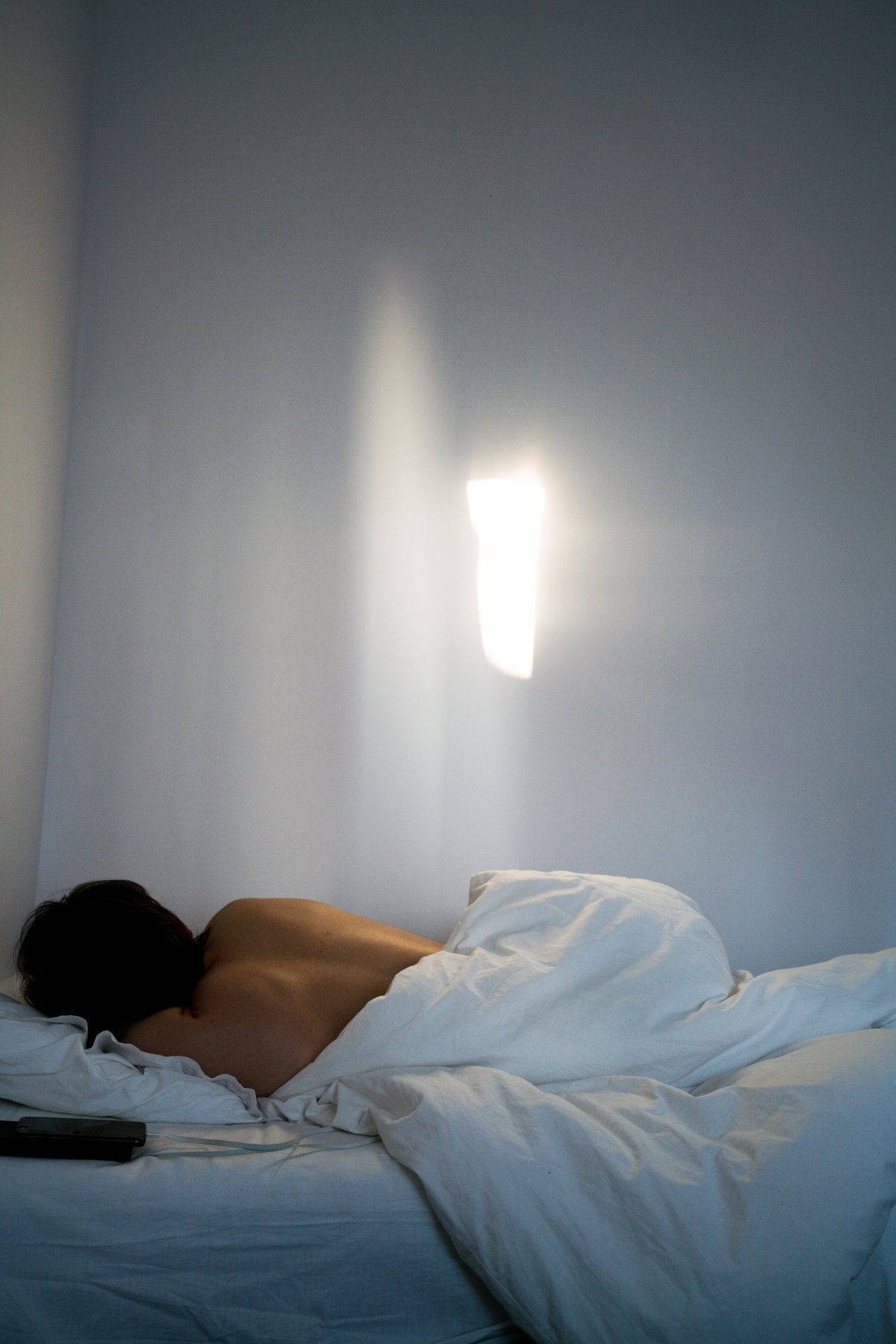 Rücken einer Frau die im Bett liegt