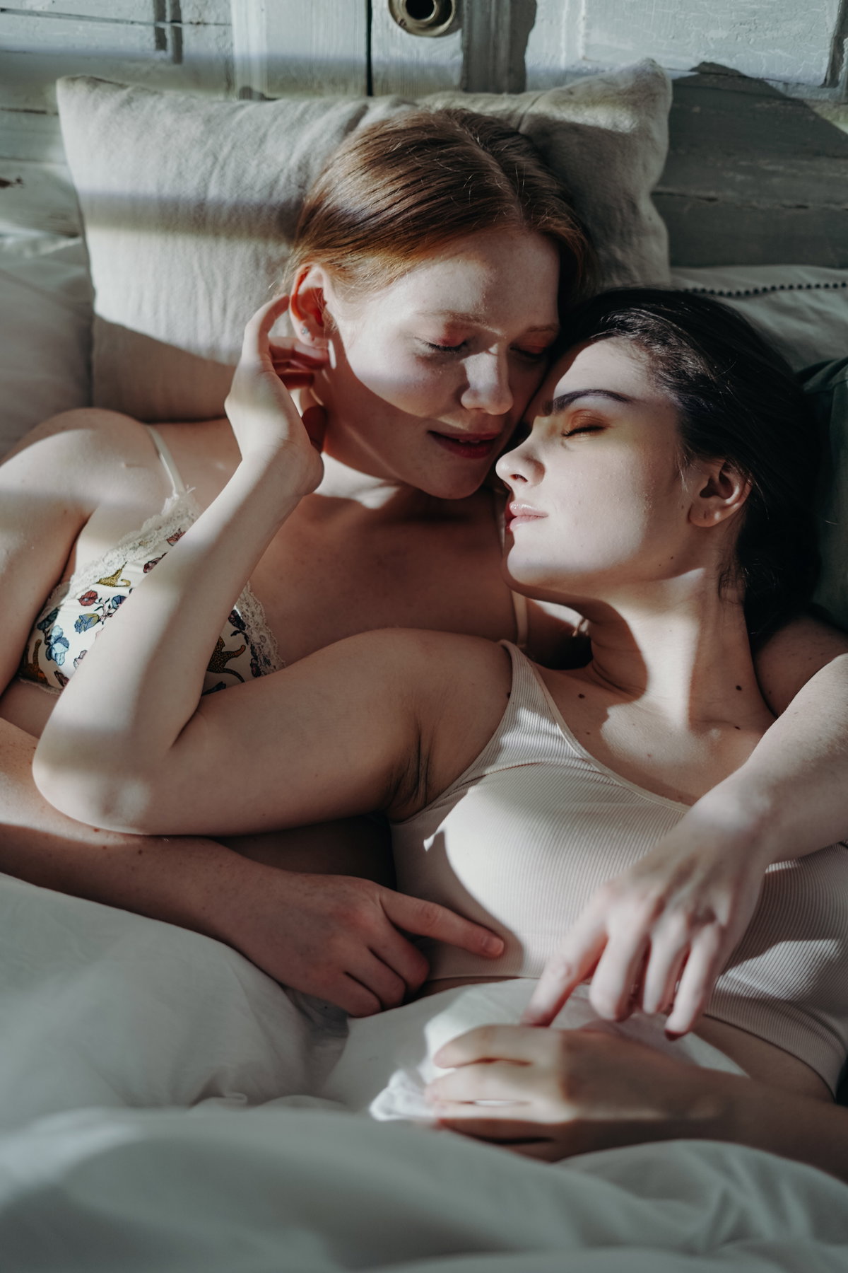 Zwei Frauen küssen sich in einem Bett