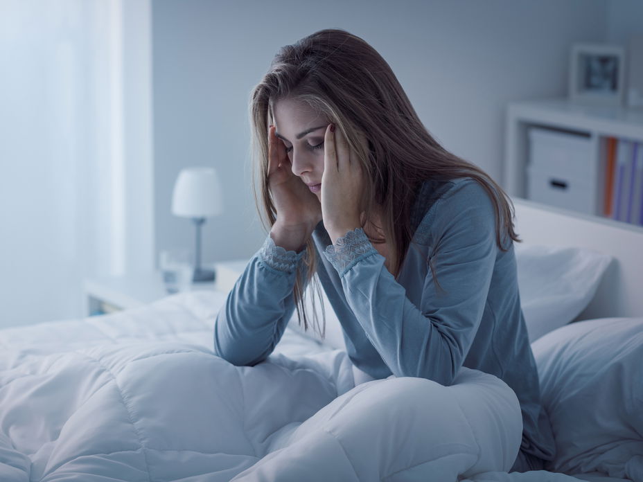 Frau total müde und unausgeschlafen im Bett