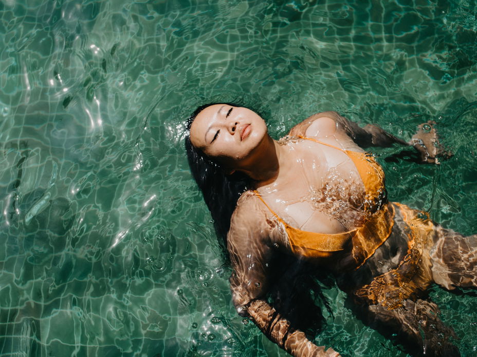 Frau im gelben Bikini im Wasser