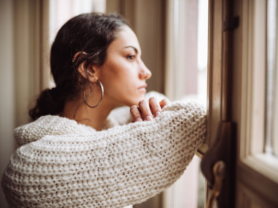 Frau nachdenklich am Fenster