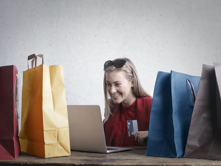 Frau vor Laptop neben Tüten