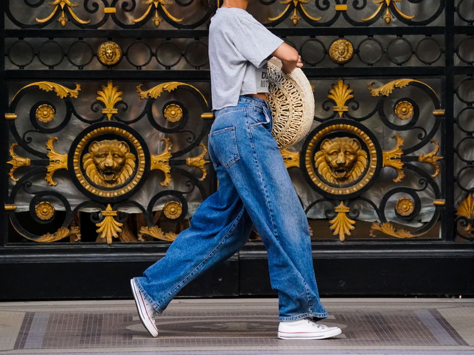Frau trägt weite Jeanshose und Chucks