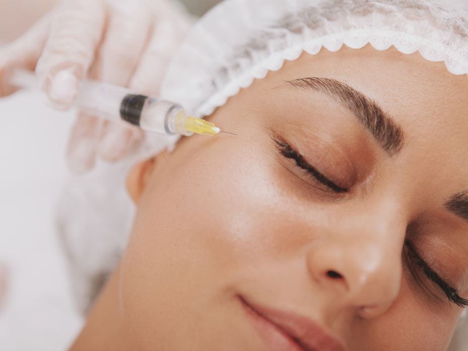 Spritze an Augenringe einer Frau mit geschlossenen Augen