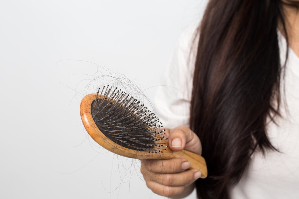 Frau hält Haarburste in der Hand