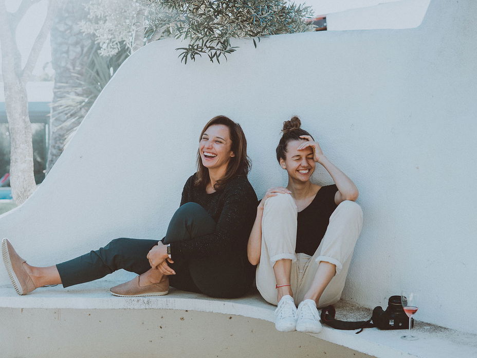 Zwei junge Frauen sitzen und lachen