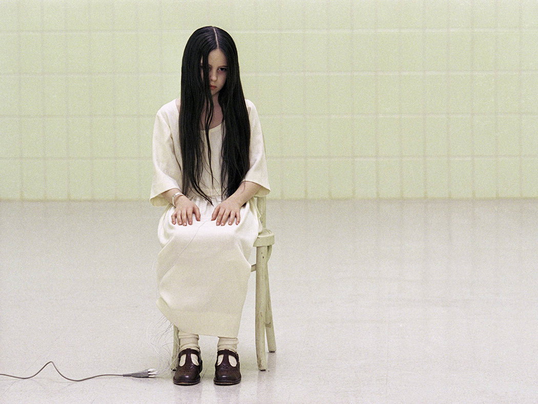 Samara von "The Ring" sitzt auf einem Stuhl