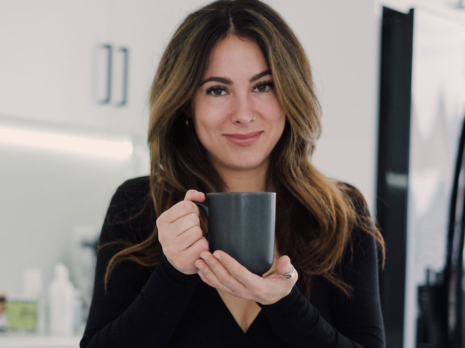 Junge Frau in der Küche mit einer Tasse in der Hand