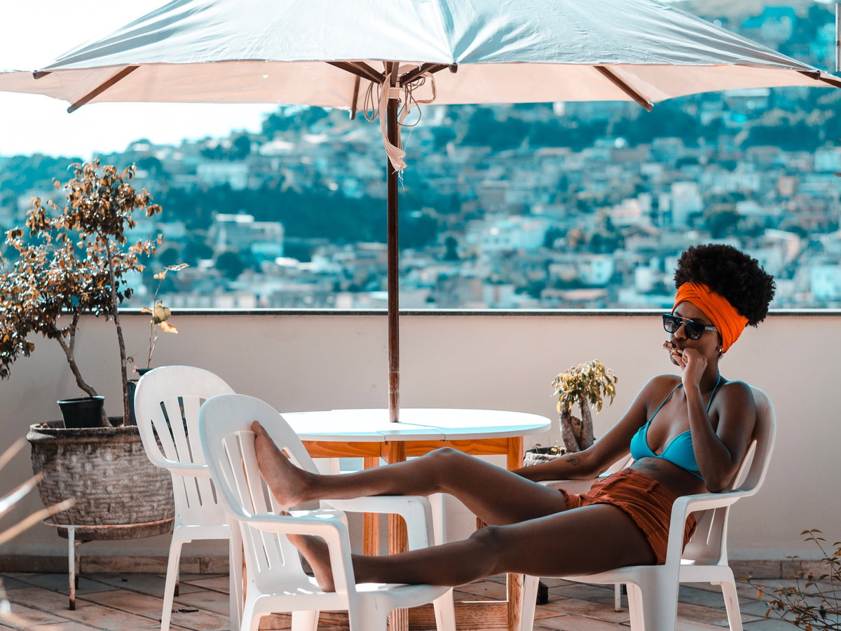 Frau liegt auf dem Balkon im Bikini