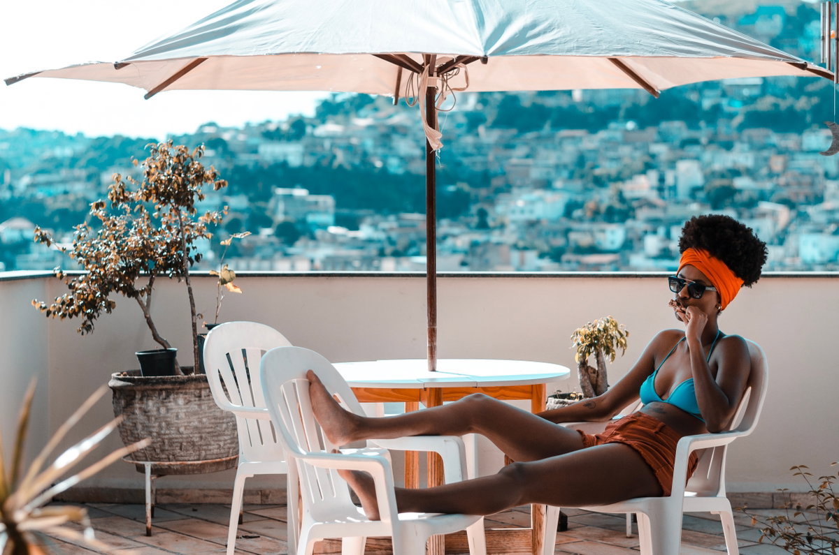 Frau liegt auf dem Balkon im Bikini