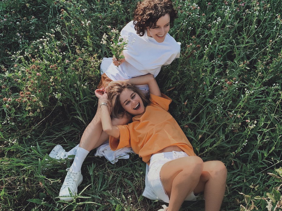 Horoskop der Woche: Zwei Frauen liegen in einem Feld