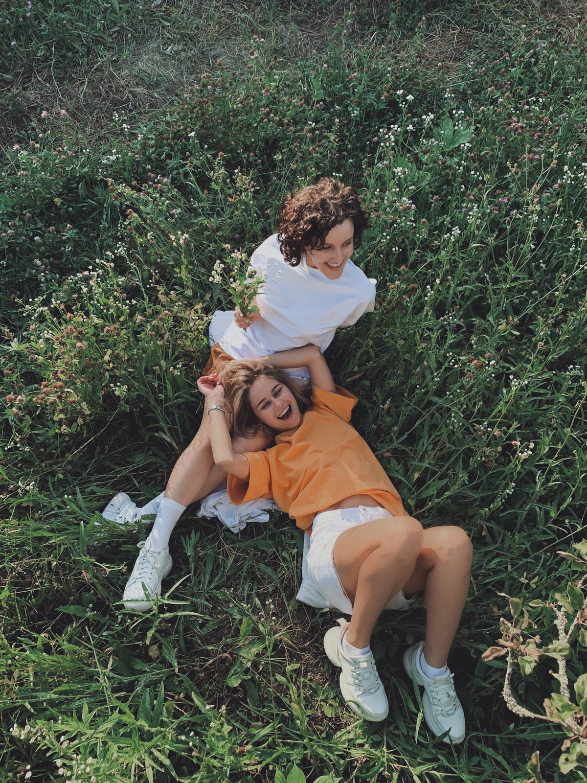 Horoskop der Woche: Zwei Frauen liegen in einem Feld