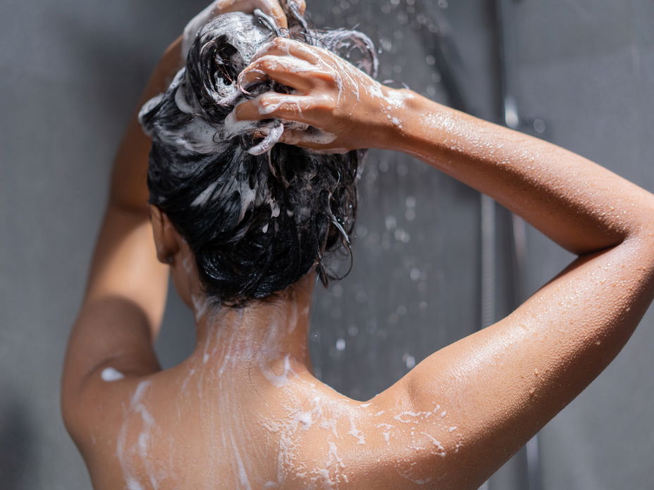 Frau wäscht Haare mit Tiefenreinigungsshampoo
