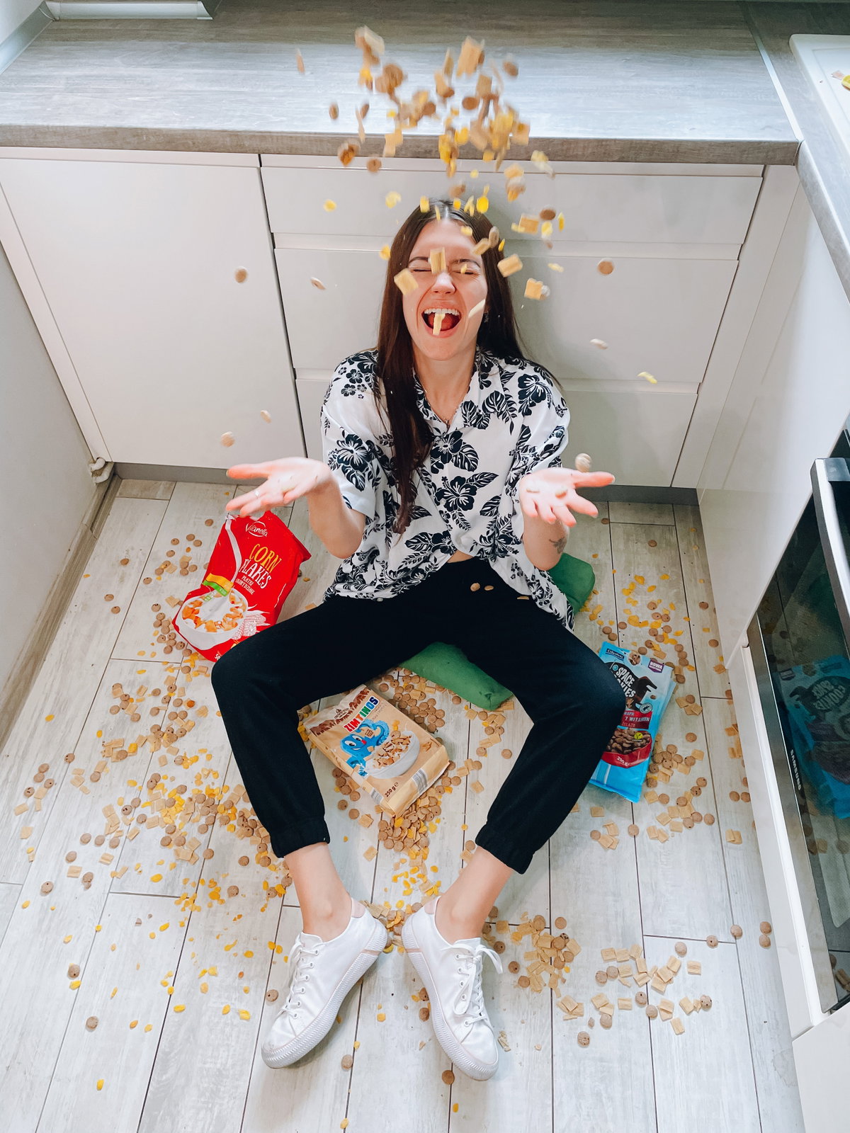 Horoskop: Frau sitzt auf Boden mit Snacks