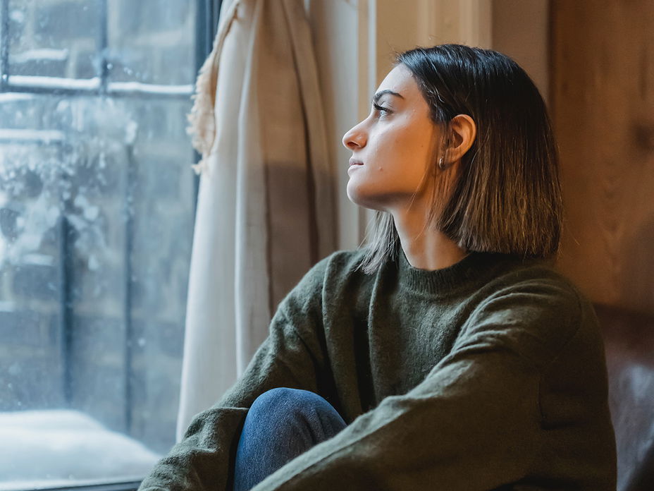 Frau schaut aus dem Fenster