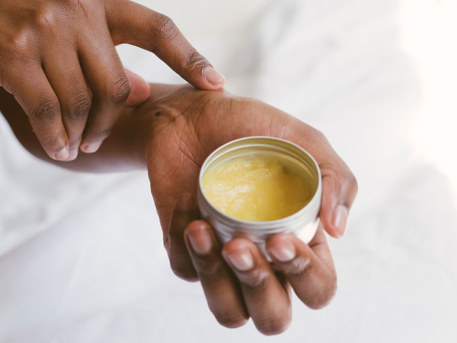 Hand hält Melkfett Creme Tube