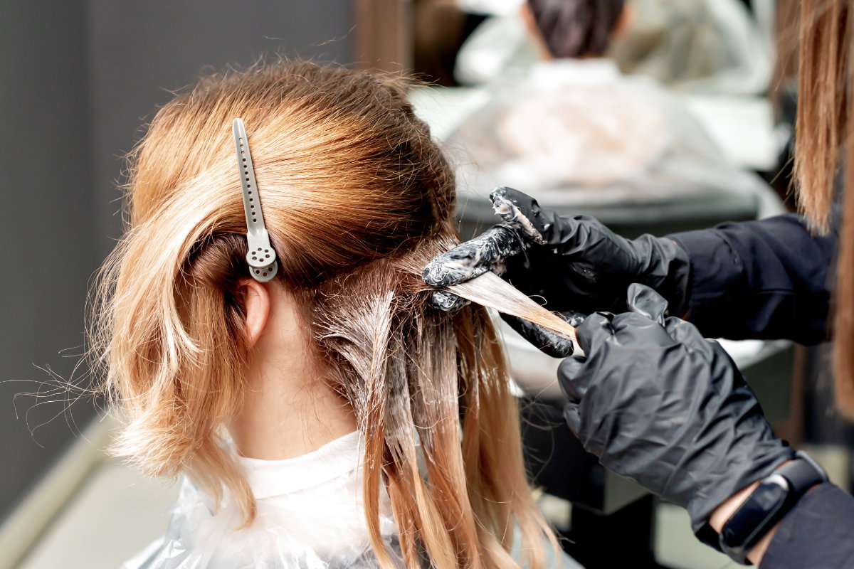 Frau färbt sich beim Friseur die Haare