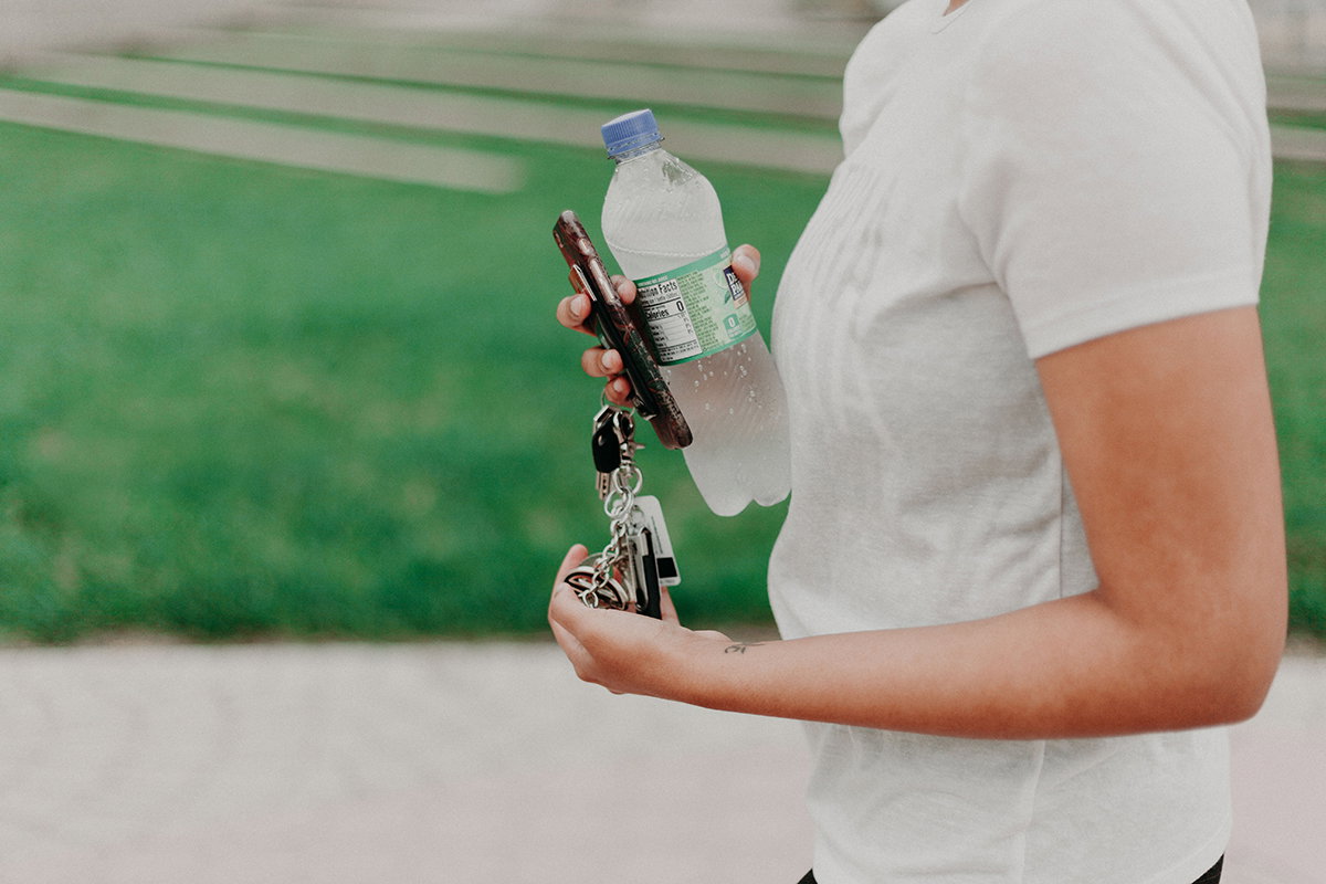 Frau hält eine Wasserflasche und Schlüssel