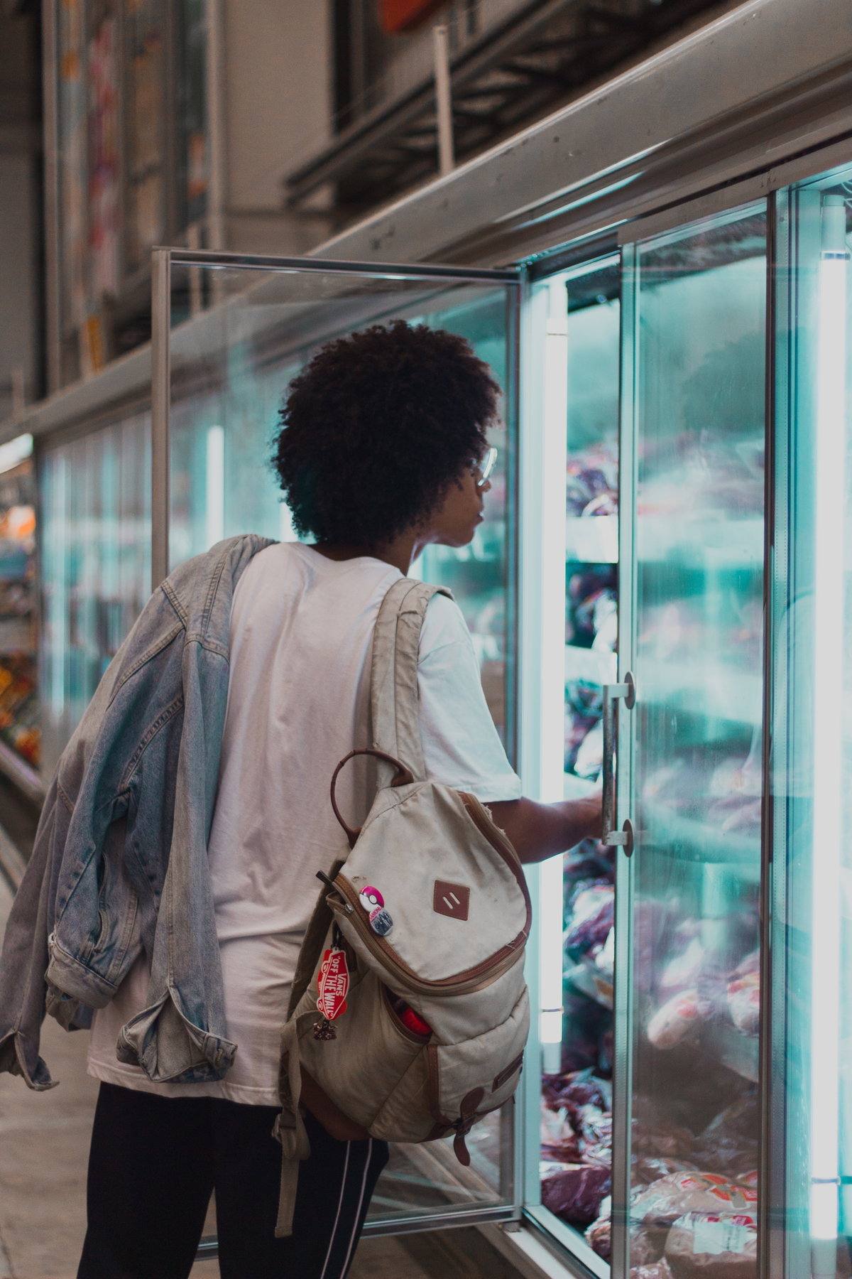 Person steht vor Supermarkt Regal