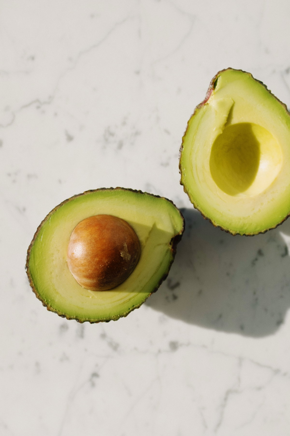 Avocadohälften auf Marmortisch