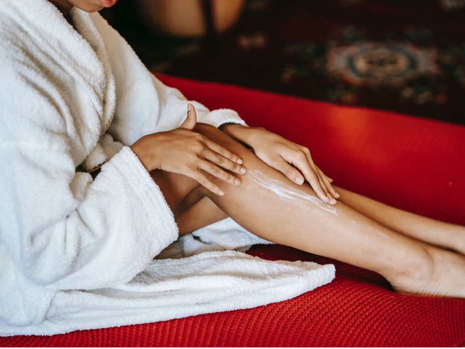Beine von Frau mit Bodylotion