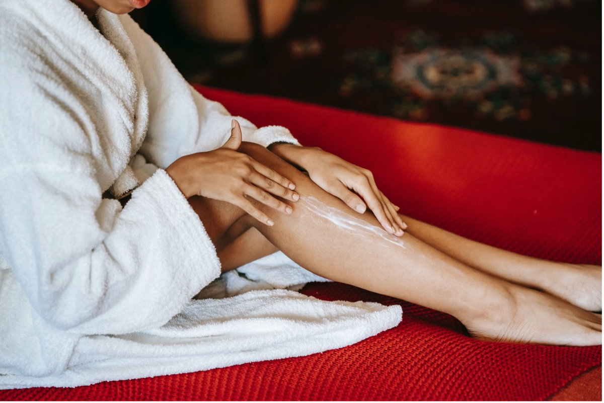 Beine von Frau mit Bodylotion