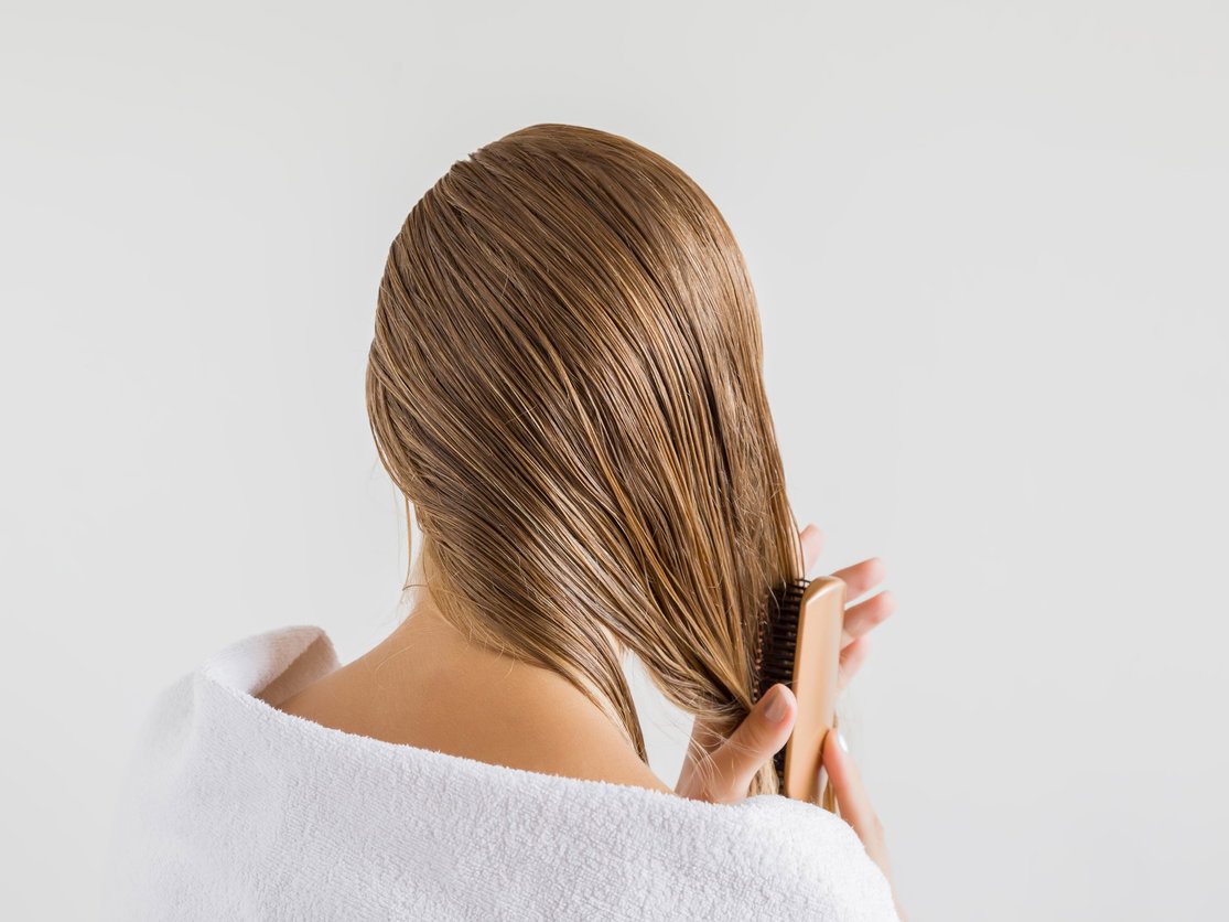 Frau pflegt blondierte Haare