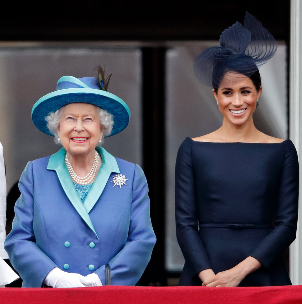 Queen und Meghan Markle stehen nebeneinander auf einem Balkon