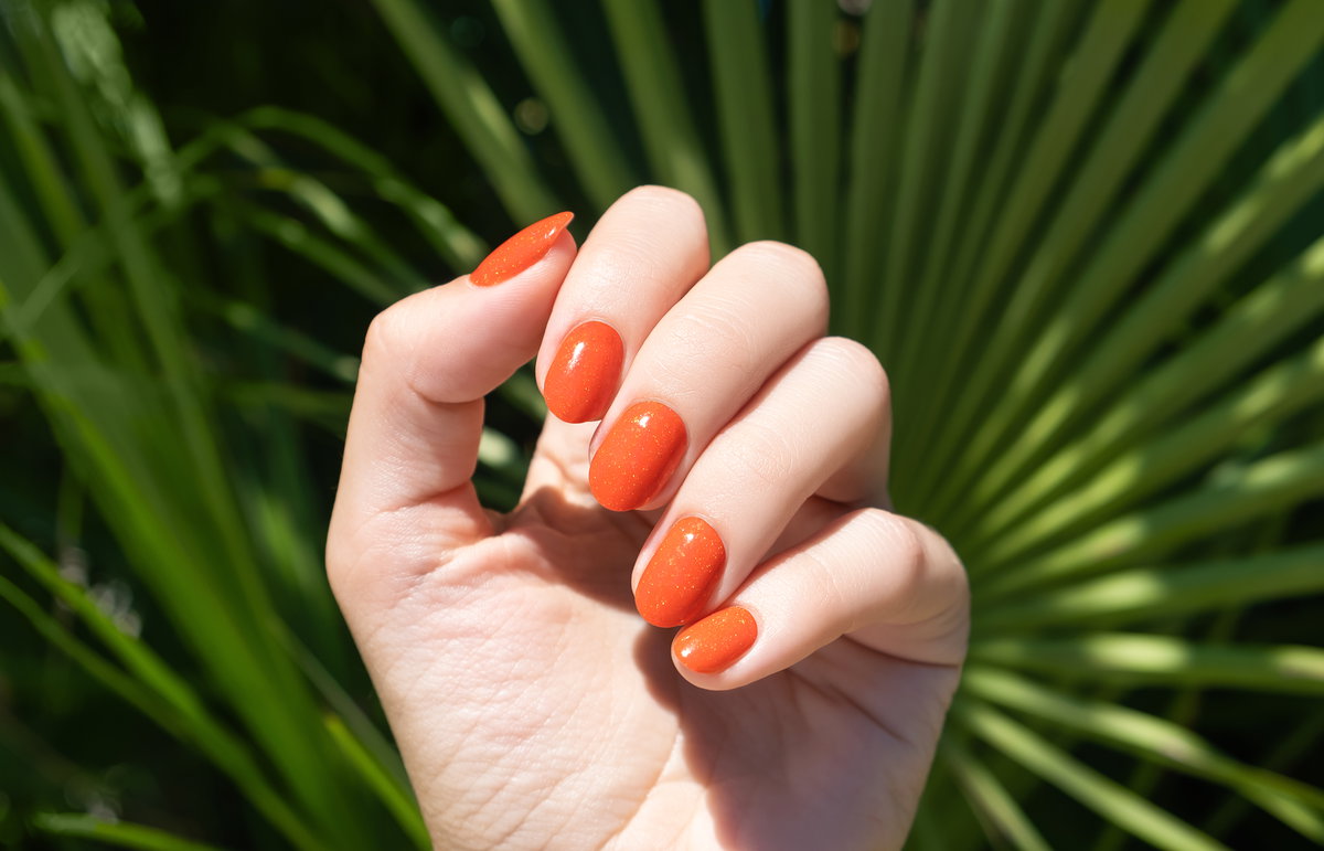 Lackierte Fingernägel in Orange