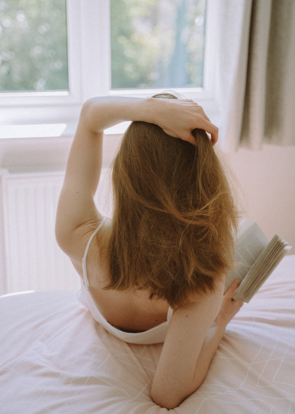 Frau liest Buch im Bett