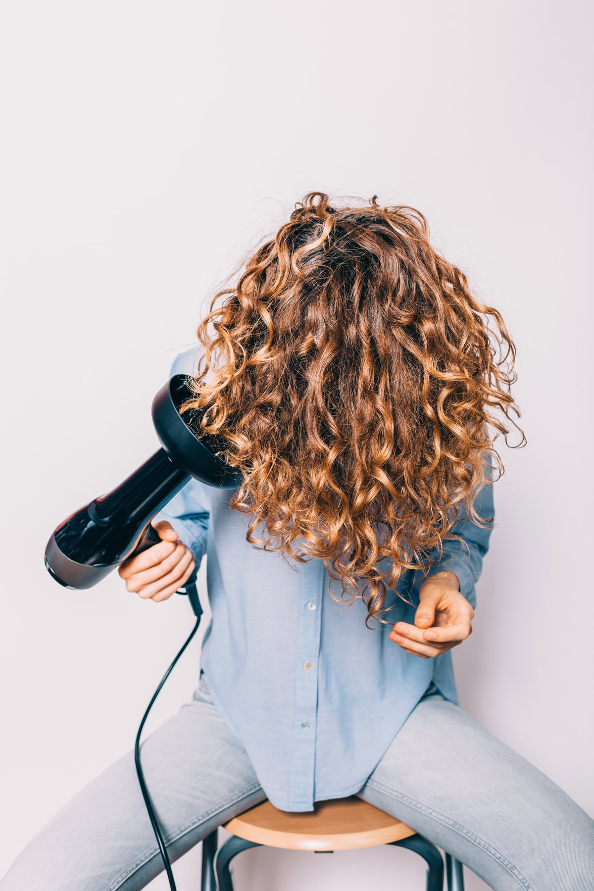 Frau föhnt sich kopfüber Haare