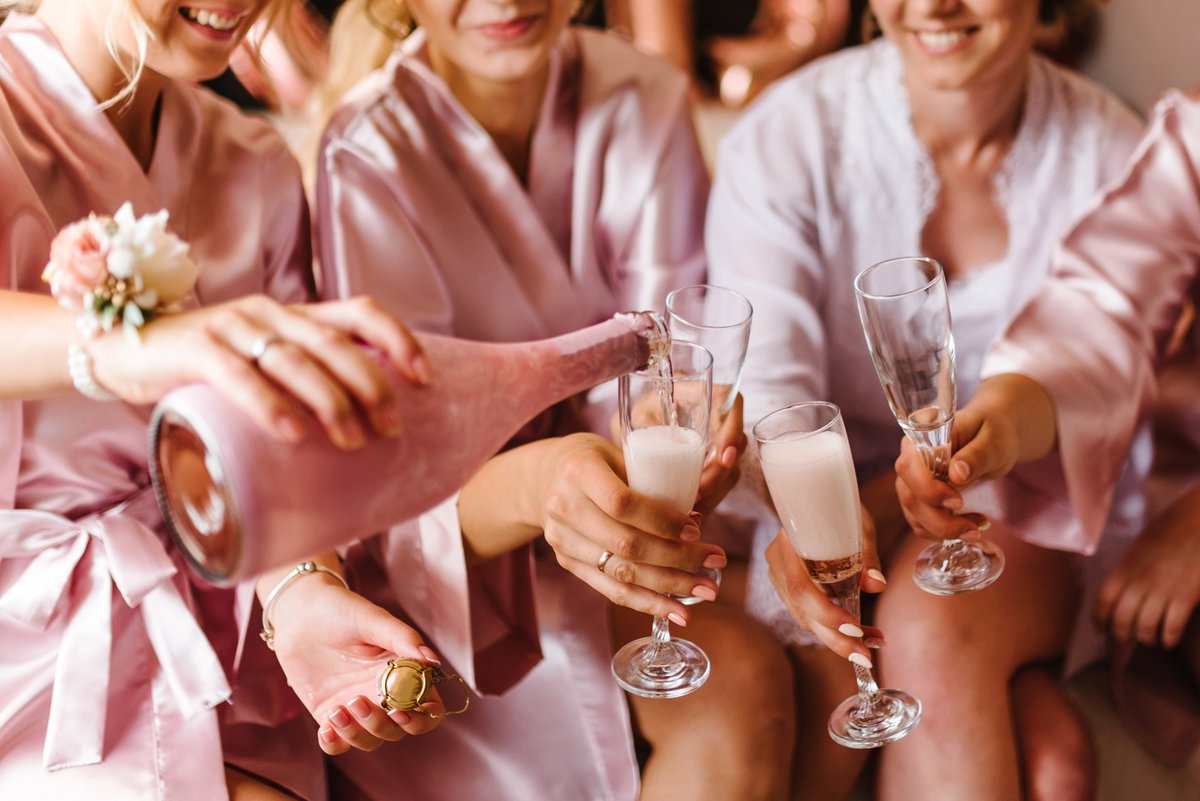 Trauzeuginnen stoßen im pinken Pyjama mit Champagner an