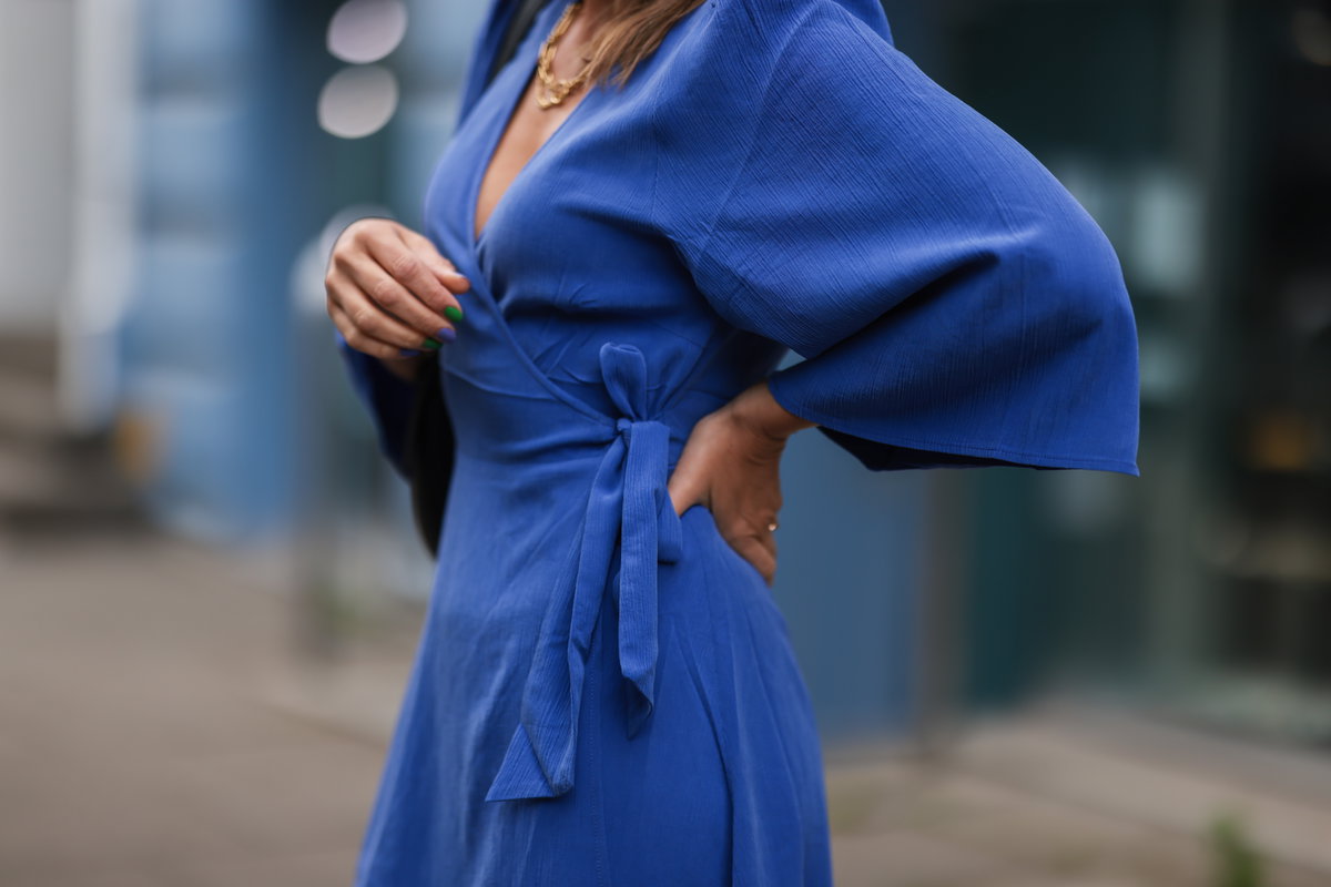 Frau trägt blaues Wickelkleid